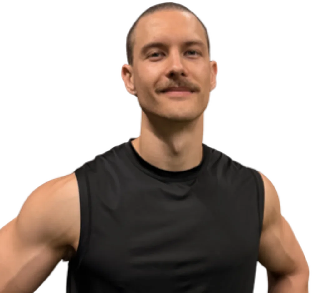 Brendon, the coach behind BC Coaching, in a black singlet with his hands on his hips.